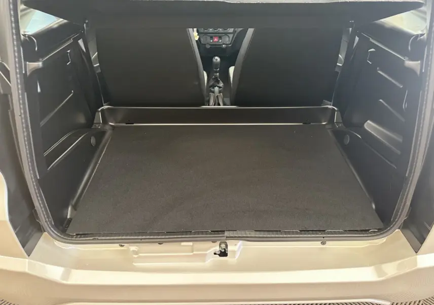 Coffre ouvert vu de l'arrière d'une AIXAM AMBITION E CITY PACK blanche, montrant l'espace de chargement et l'intérieur noir.