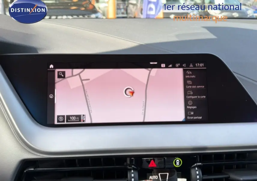 Vue intérieure du tableau de bord de la BMW Série 1 116i 2022 avec écran tactile affichant la navigation.
