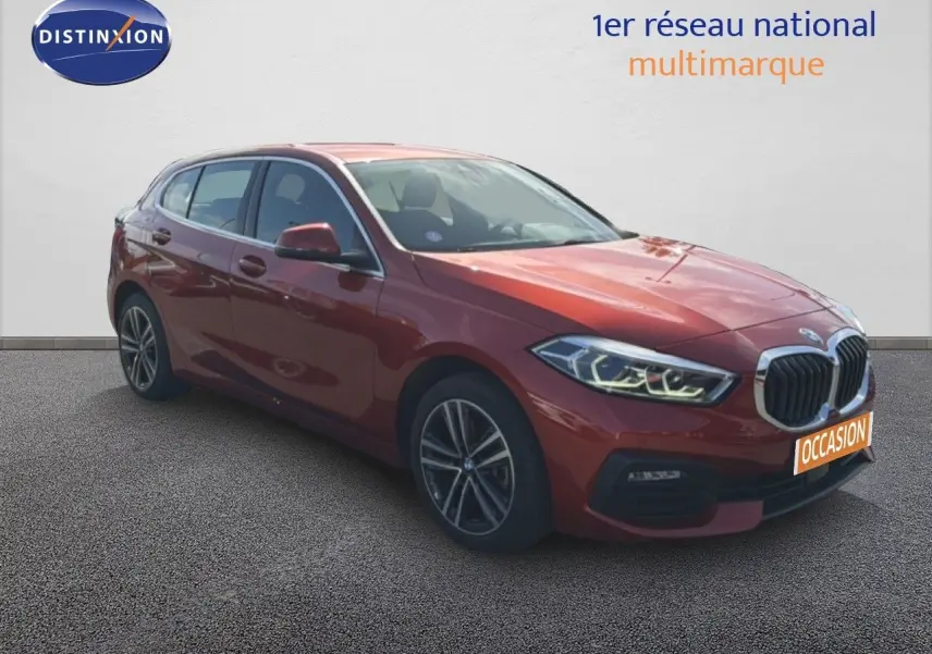 BMW Série 1 116i orange Sunset vue 3/4 avant droit avec phares LED et jantes alliage biton.