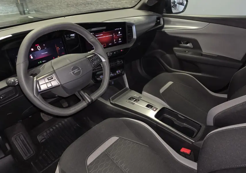 Vue intérieure côté conducteur de l'Opel Mokka 2025, volant TEP, écran tactile 10'', sellerie tissu noir et gris.