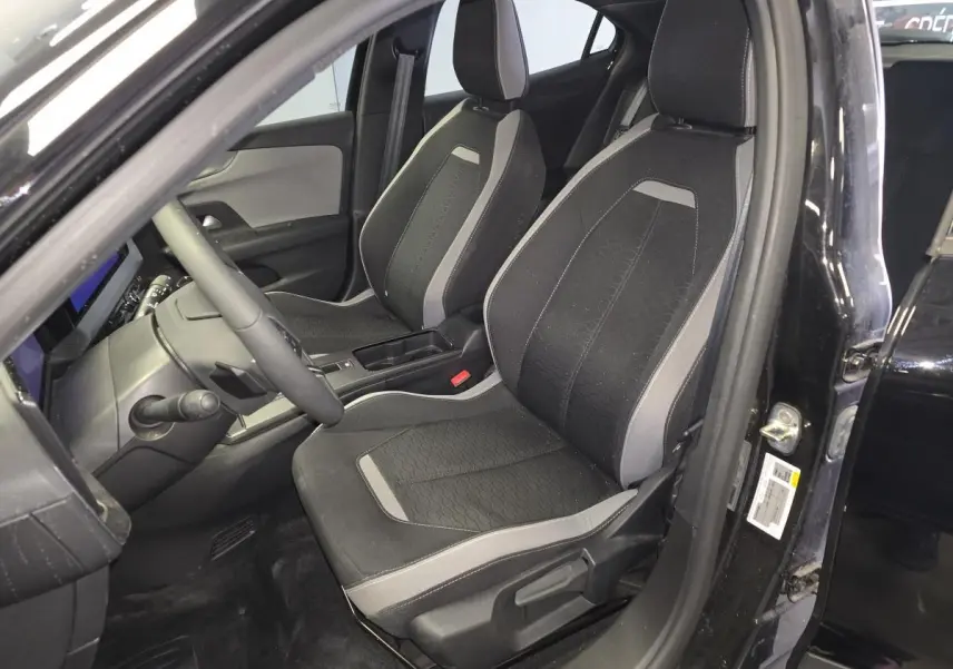 Vue intérieure côté conducteur de l’Opel Mokka noire 2025, sièges tissu gris et noir avec détails modernes.