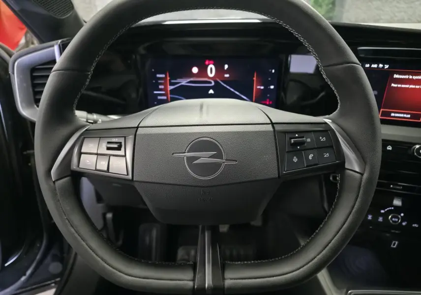 Vue rapprochée du volant noir de l’Opel Mokka 2025 avec commandes intégrées et tableau de bord digital.