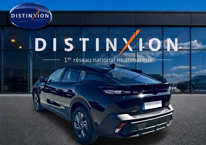Peugeot 408 Hybrid noir vue 3/4 arrière droit, avec feux arrière LED et jantes alu visibles devant une vitrine Distinxion.