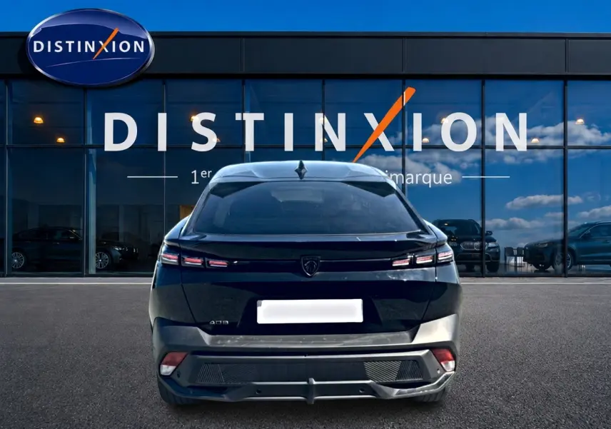 Vue arrière d'une Peugeot 408 Hybrid 145 allure e-dcs6 noire, avec feux LED distinctifs et lunette arrière surteintée.