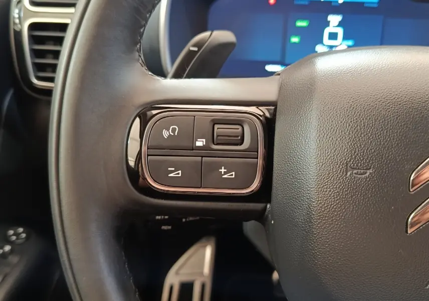 Gros plan sur les commandes gauche du volant cuir noir du Citroën C5 Aircross Hybrid 225 ë-EAT8 Shine Pack 2021.