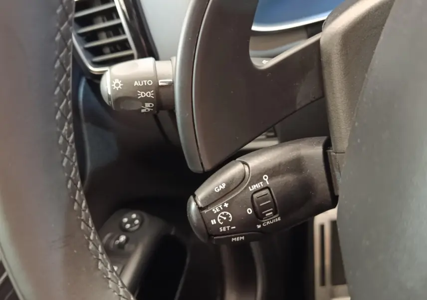 Gros plan sur les commandes au volant d’un Citroën C5 Aircross Hybrid 225 ë-EAT8, intérieur noir.
