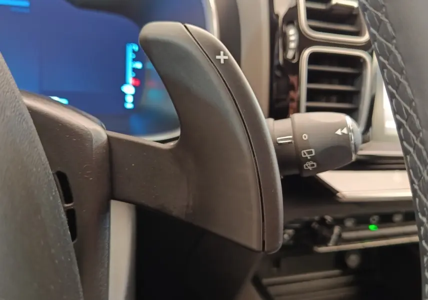 Gros plan sur la palette de changement de vitesse droite du volant cuir du Citroën C5 Aircross Hybrid gris foncé, intérieur moderne.