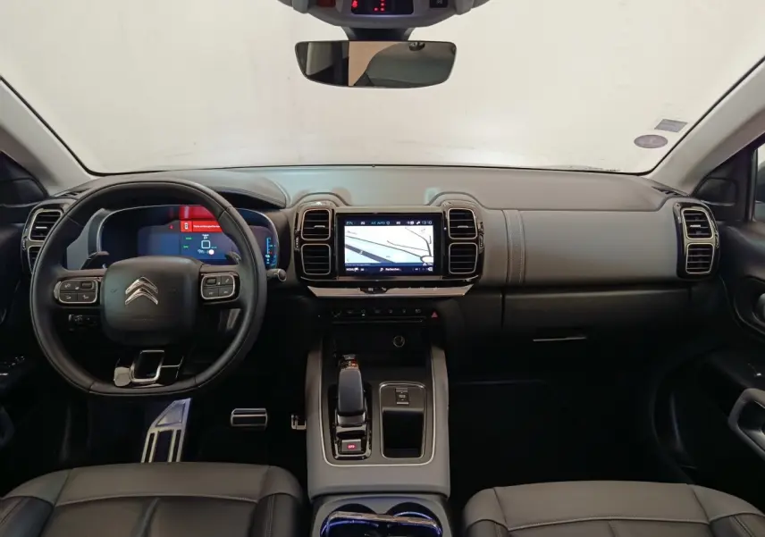 Vue intérieure frontale du tableau de bord et volant cuir noir du Citroën C5 Aircross Hybrid 225 ë-EAT8 Shine Pack.