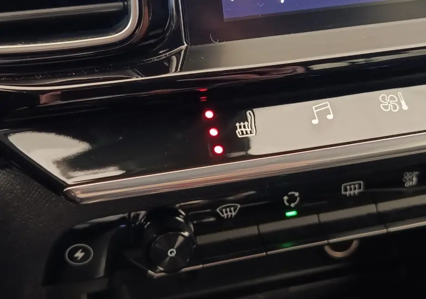 Détail du tableau de bord noir du Citroën C5 Aircross Hybrid 225, avec commandes tactiles et voyants rouges allumés.