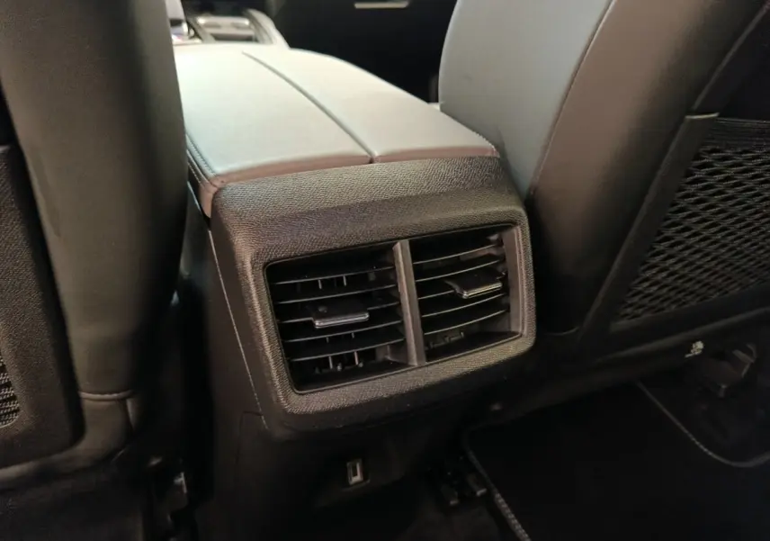 Gros plan sur la console centrale arrière avec bouches d’aération et port USB du Citroën C5 Aircross Hybrid gris foncé.