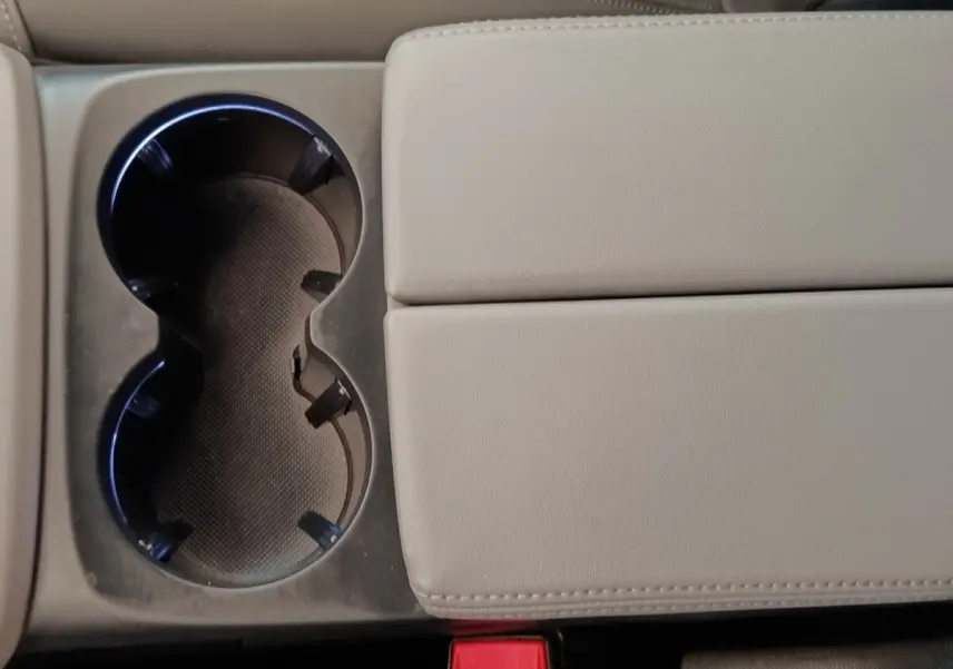 Gros plan sur la console centrale beige avec porte-gobelets et accoudoir du Citroën C5 Aircross Hybrid 225 ë-EAT8 Shine Pack.