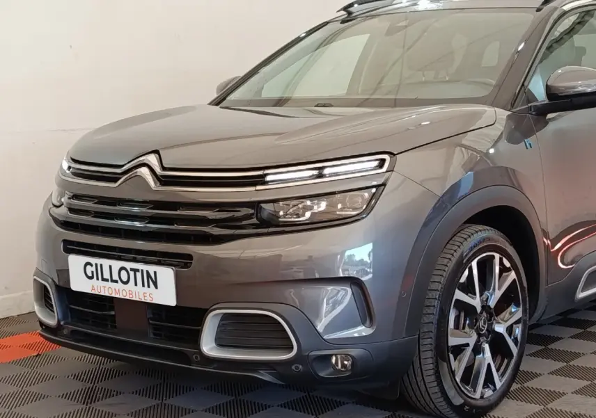 Vue 3/4 avant droite d'un Citroën C5 Aircross Hybrid gris foncé avec phares LED et jantes alliage distinctives.