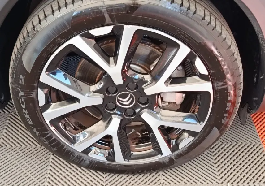 Gros plan sur la jante alliage bicolore et le pneu Pirelli d’un Citroën C5 Aircross Hybrid gris foncé.