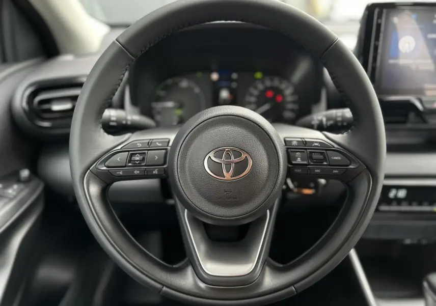 Volant en cuir noir de Toyota Yaris 2025 Hybride, vue frontale centrée sur les commandes multifonctions.