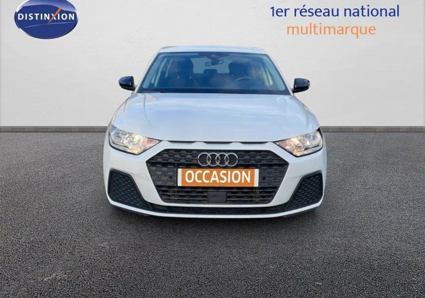Vue de face d'une Audi A1 Sportback blanche glacier métal avec calandre noire et plaque "OCCASION" orange.