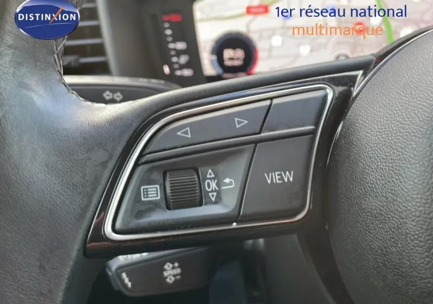 Gros plan sur les commandes au volant de l'Audi A1 Sportback 30 TFSI 110ch 2023, finition noire et chrome.