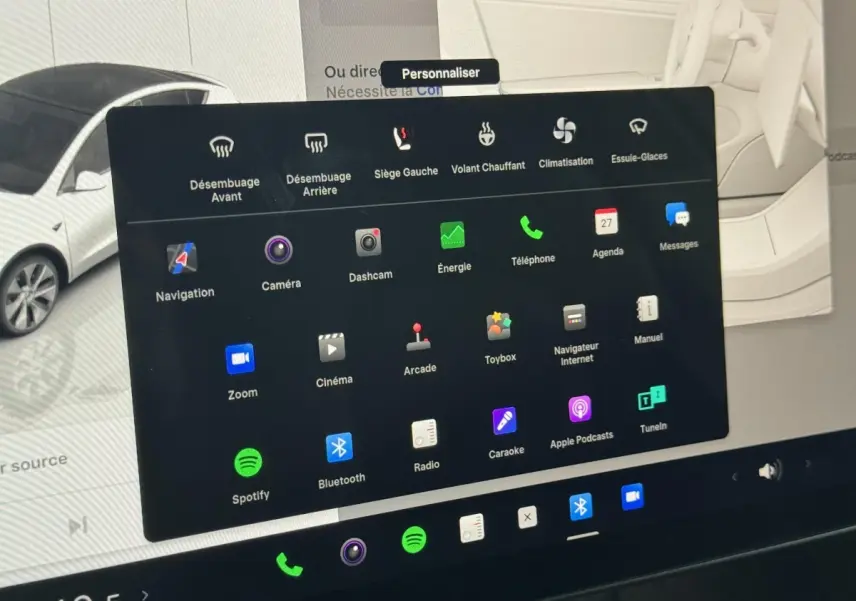 Vue partielle de l'écran tactile central affichant les options de personnalisation dans une Tesla Model Y blanche de 2022.