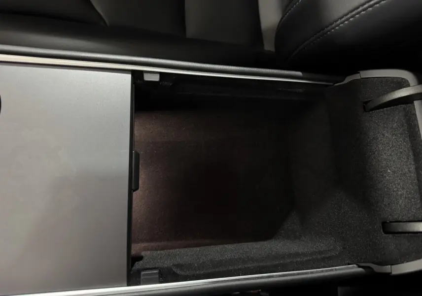 Vue en plongée sur le rangement central intérieur noir du Tesla Model Y Grand Autonomie 2022.