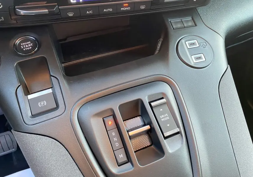 Gros plan sur la console centrale noire du Peugeot Rifter 2026 avec sélecteur de boîte auto et boutons Drive Mode et Start/Stop.