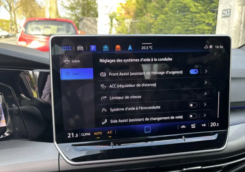 Écran tactile central de la Volkswagen Golf 1.5 eTSI 2024 montrant les réglages des aides à la conduite, intérieur noir.