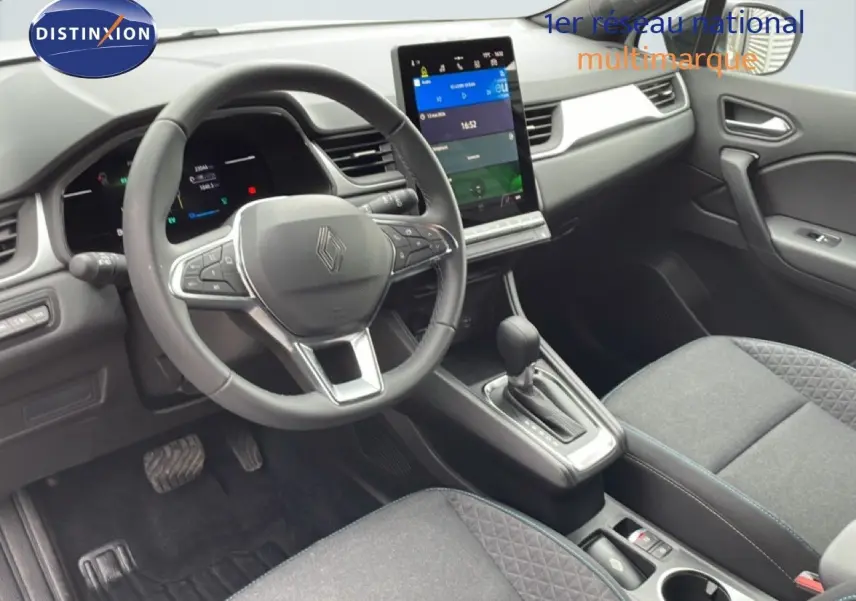Vue intérieure côté conducteur du Renault Symbioz gris Rafale Métal, avec volant multifonction et écran tactile central vertical.