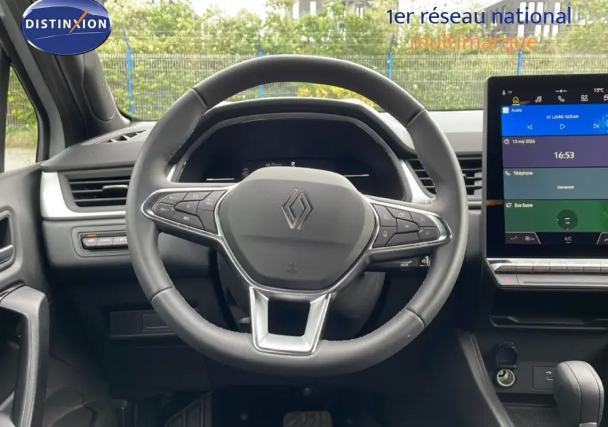 Vue intérieure centrée sur le volant cuir et l’écran tactile du tableau de bord de la Renault Symbioz gris Rafale Métal.