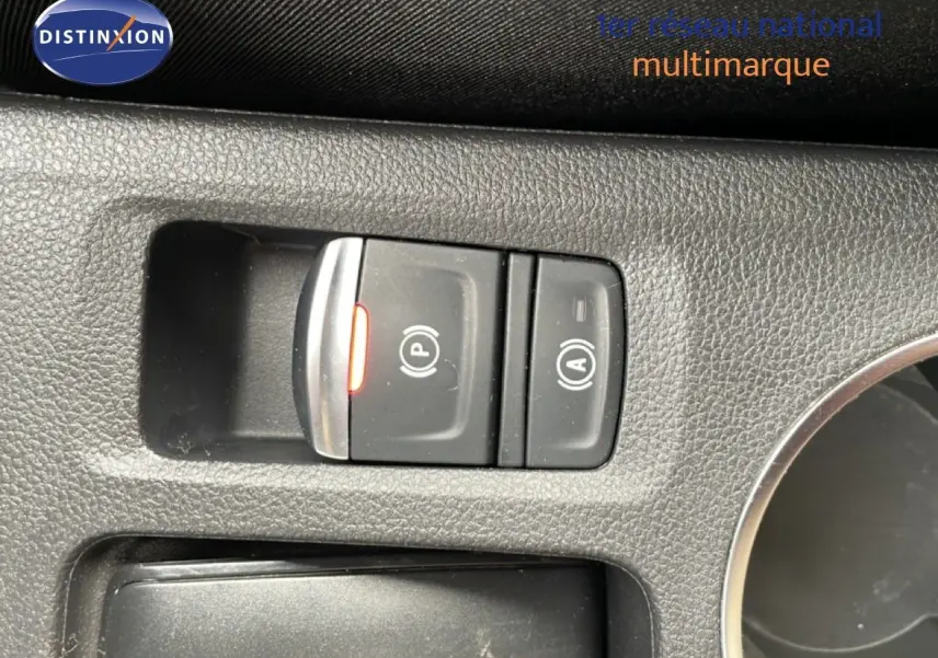 Gros plan sur les commandes de frein à main électronique et arrêt automatique du moteur, intérieur noir du Renault Symbioz.