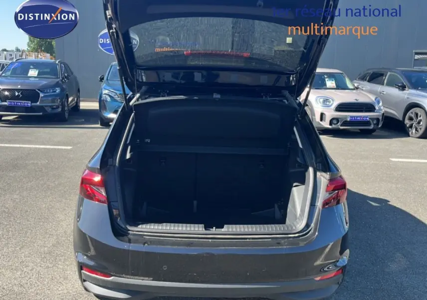 Vue arrière d'une Skoda Fabia noire avec le coffre ouvert, montrant l'espace de chargement vide en extérieur.