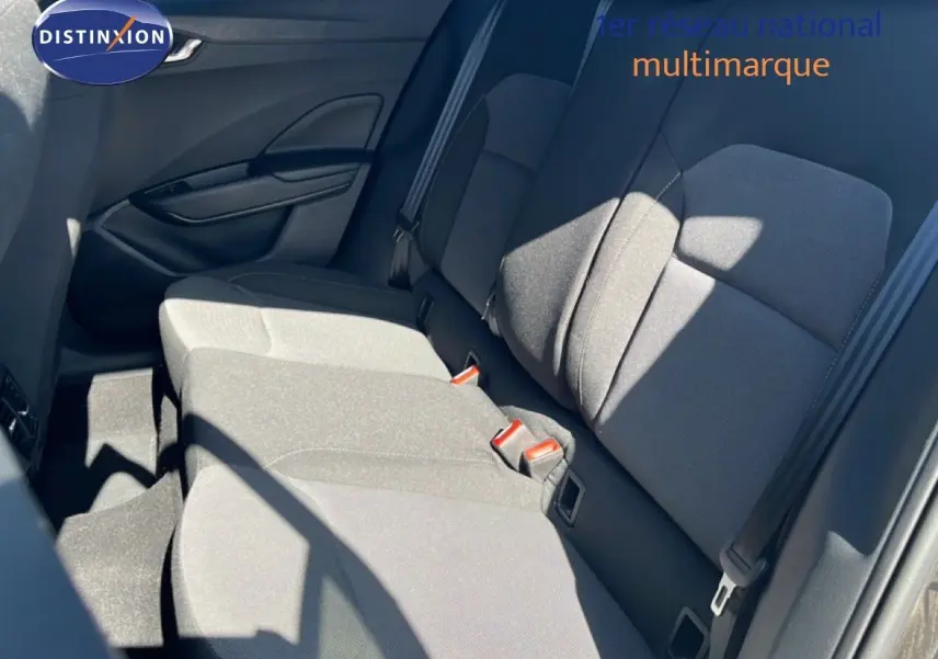 Vue intérieure des sièges arrière en tissu gris noir de la Skoda Fabia 2025, avec ceinture de sécurité et porte côté gauche visible.