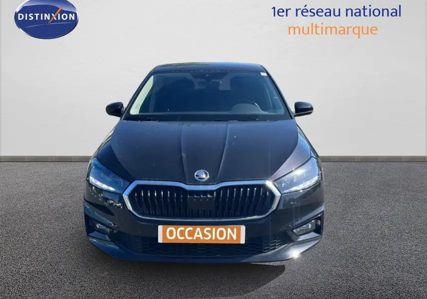Vue de face d'une Skoda Fabia noire métal 2025 avec calandre chromée et phares LED allumés.