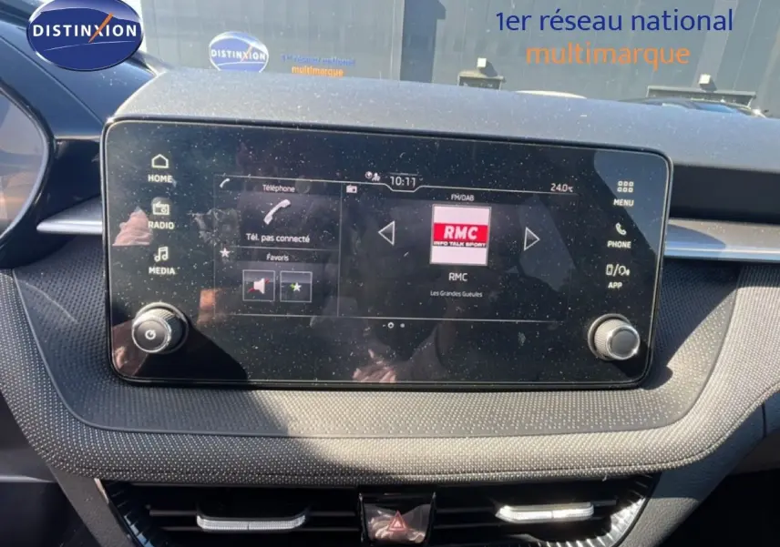 Écran tactile central de la Skoda Fabia 2025 en noir magique métal, affichant la radio RMC dans l'habitacle.