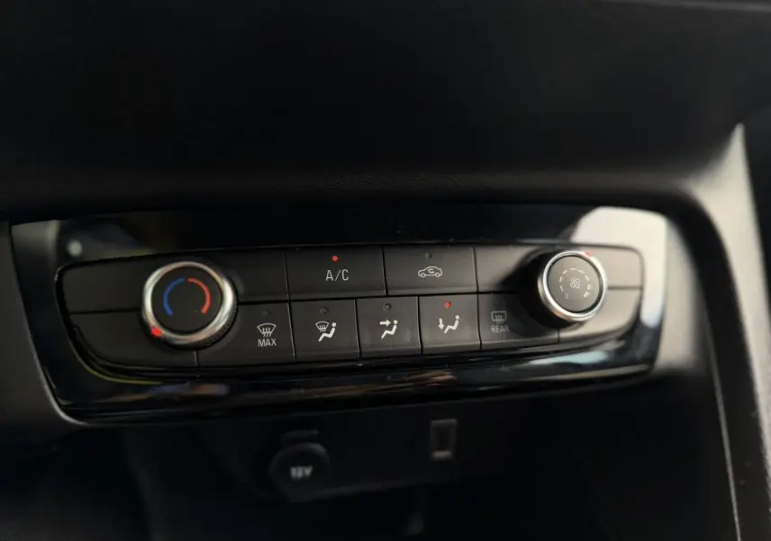 Détail de la console centrale noire de l’Opel Corsa 2025 avec commandes de climatisation manuelle.