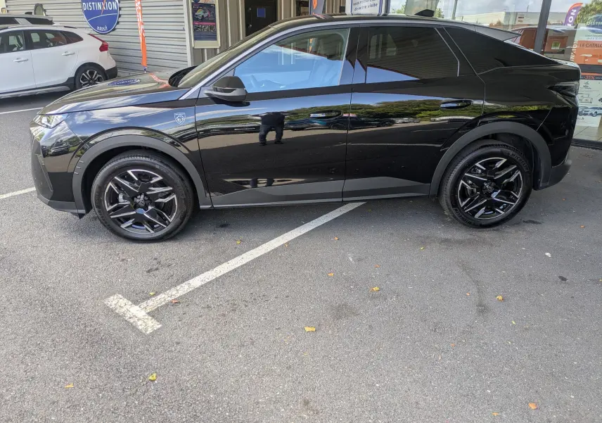 Profil côté gauche du Peugeot 3008 Hybrid 145 GT noir brillant avec jantes noires et vitres teintées, stationné devant un bâtiment.