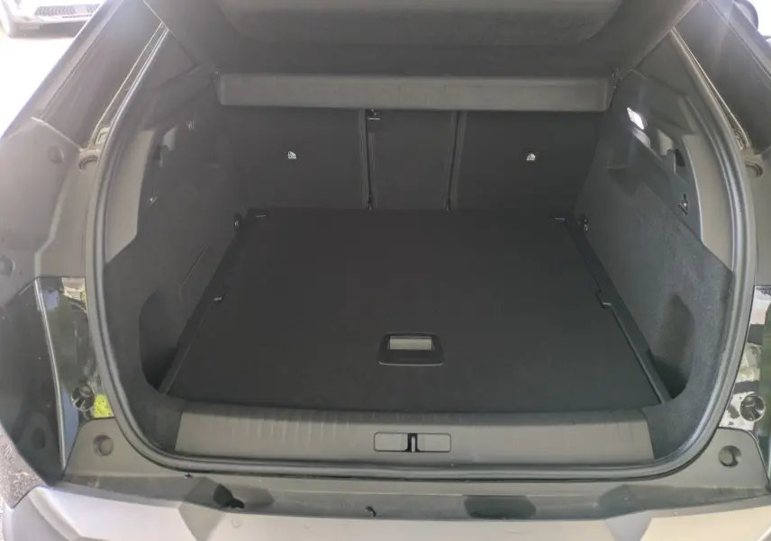 Coffre ouvert d’un Peugeot 3008 Hybrid 145 noir, vue arrière montrant un espace de chargement propre et spacieux.