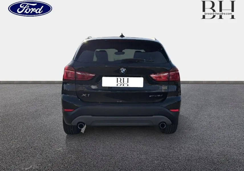 Vue arrière d'un BMW X1 sDrive18dA 2018 noir Saphirschwarz avec double sortie d'échappement et feux rouges.