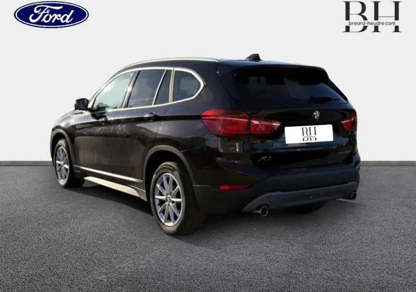 BMW X1 sDrive18dA 2018 en saphirschwarz, vue 3/4 arrière droit avec échappement double et jantes alu.