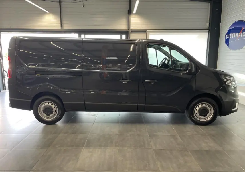 Profil côté droit du Renault Trafic Fourgon L2H1 2025 en gris comète, avec jantes tôles 16 pouces et porte coulissante.