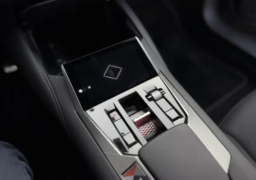 Gros plan sur la console centrale du DS4 2025 avec commandes tactiles et finition chromée moderne.
