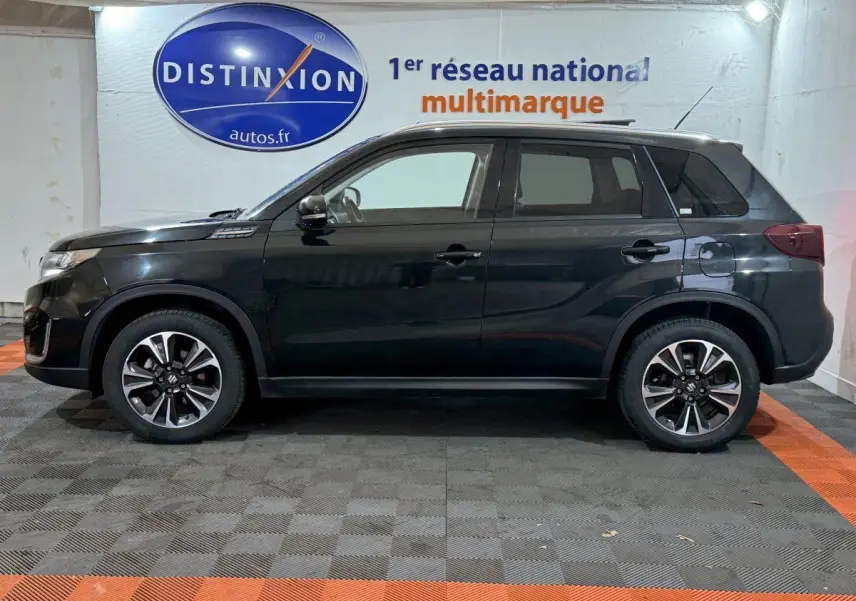 Profil côté gauche d'un Suzuki Vitara noir 2022 hybride, avec jantes alliage et toit ouvrant en verre.