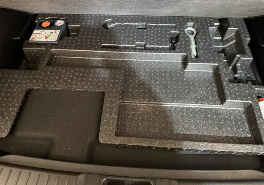 Rangement en mousse noire dans le coffre du Suzuki Vitara 1.5 Dualjet hybrid STYLE 2022, compartiments pour outils.