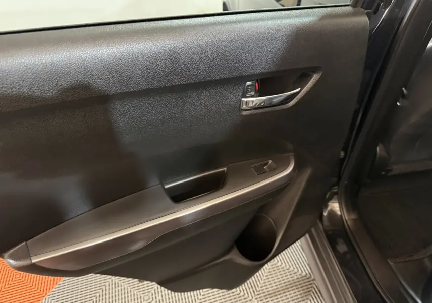 Vue rapprochée de la porte arrière droite noire du Suzuki Vitara 2022, avec poignée chromée et commande de vitre.