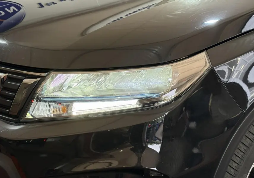 Gros plan sur le phare avant droit du Suzuki Vitara noir 2022, mettant en valeur les détails du bloc optique.