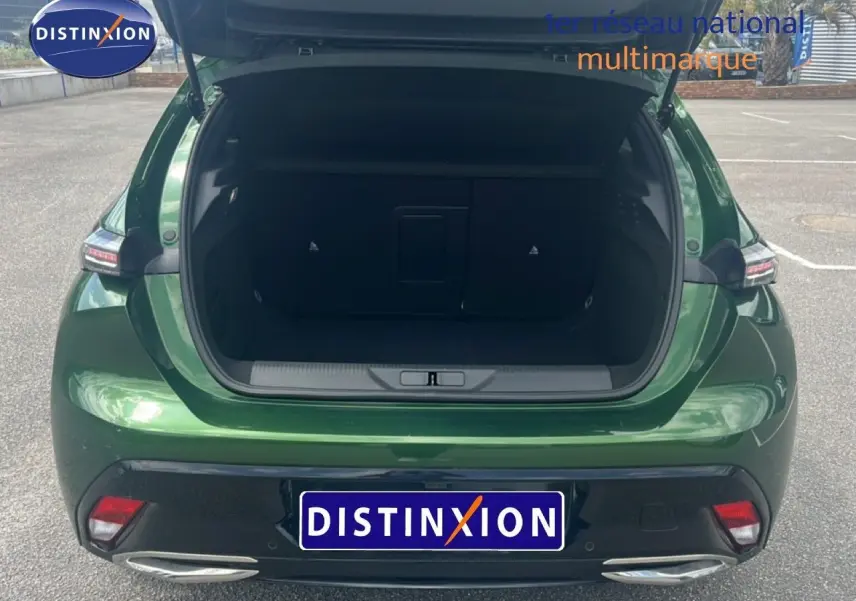 Vue arrière ouverte de la Peugeot 308 2024 vert olivine métal, coffre spacieux et feux arrière modernes visibles.