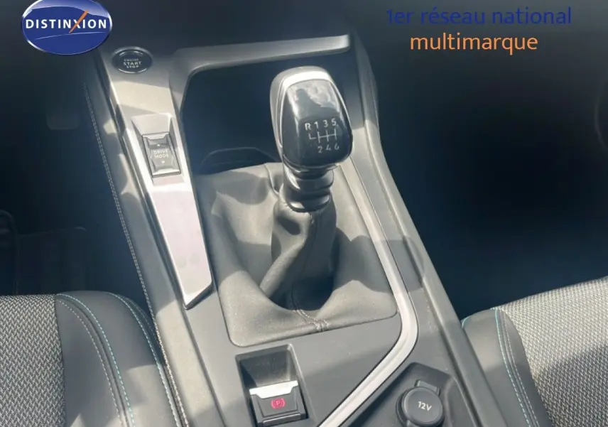 Vue rapprochée de la console centrale d’une Peugeot 308 2024, boîte manuelle avec levier de vitesse et bouton Drive Mode.