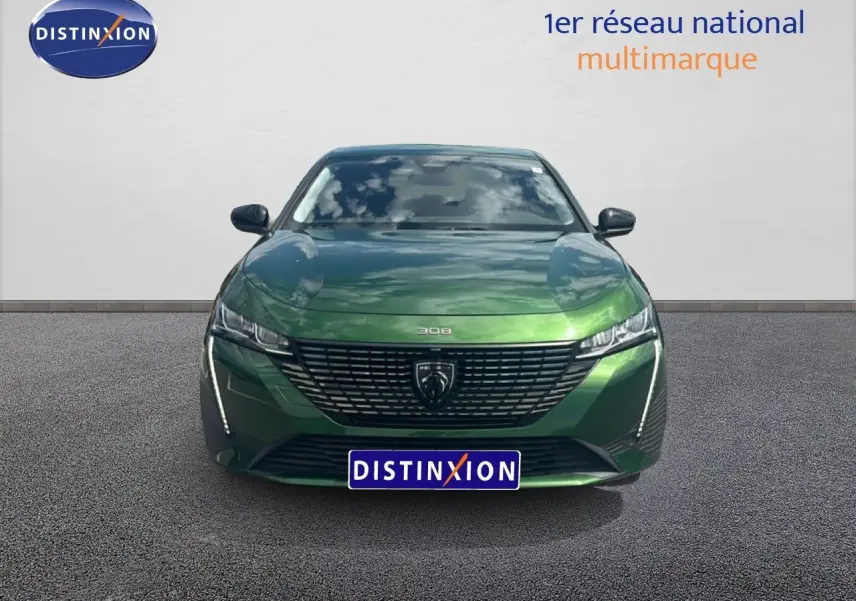 Vue avant d'une Peugeot 308 2024 vert olivine métallisé avec calandre noire et logo central distinctif.