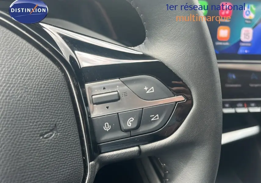 Gros plan sur les commandes multifonctions à droite du volant cuir noir d’une Peugeot 308 1.2 PureTech 130ch Allure 2024.