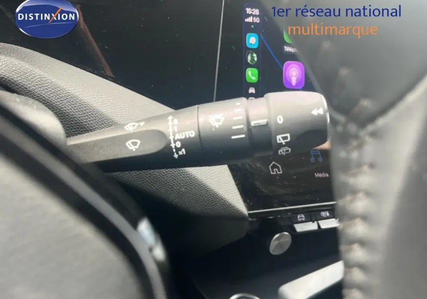Gros plan sur la commande d’essuie-glace à gauche du volant dans l’habitacle d’une Peugeot 308 vert olivine 2024.