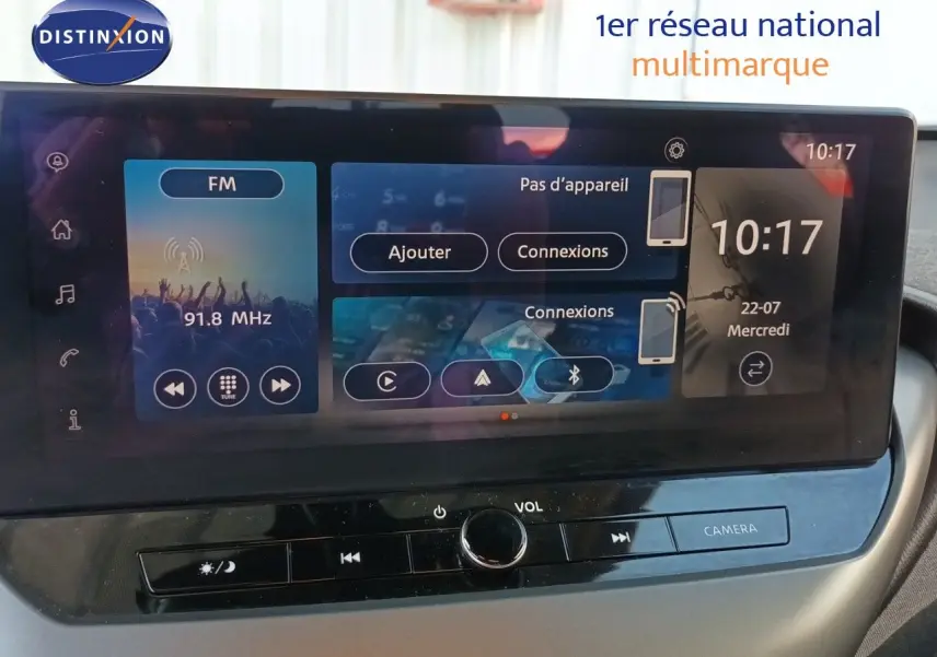 Écran tactile central du Nissan Juke Hybrid 2025 affichant la radio FM et les options de connexion, vue intérieure frontale.