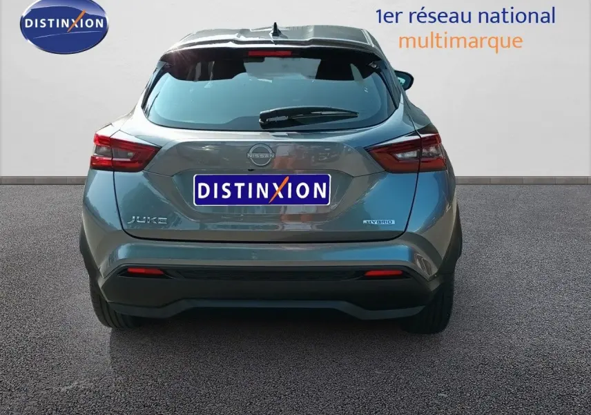 Vue arrière d'un Nissan Juke hybride gris squale métal 2025 avec feux arrière LED et logo distinctif.