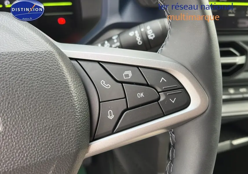 Gros plan sur les commandes multifonctions à droite du volant du Dacia Duster 2025, intérieur noir.